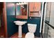 Bathroom with pedestal sink, wood cabinetry, and glass shower door at 112 Coronado Rd, Indianapolis, IN 46234