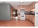 View of the kitchen area showing light wood cabinets, black countertops, and white appliances at 112 Coronado Rd, Indianapolis, IN 46234