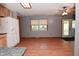 Kitchen and dining room area with laminate flooring, window, ceiling fan, and neutral gray walls at 112 Coronado Rd, Indianapolis, IN 46234