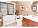 Cozy bathroom featuring a tub and shower combination, wood vanity, and decorative accents at 114 E 27Th St, Indianapolis, IN 46205
