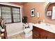 Well-lit bathroom featuring warm colored walls, a bathtub, and a vanity at 114 E 27Th St, Indianapolis, IN 46205