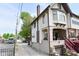 A two-story home featuring a covered porch with seating, brick accents, and a side driveway at 114 E 27Th St, Indianapolis, IN 46205