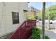 Exterior of townhouse displaying a red staircase leading to a deck and a fenced in area at 114 E 27Th St, Indianapolis, IN 46205