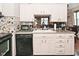 Bright kitchen with white cabinets, mosaic backsplash, and black dishwasher at 114 E 27Th St, Indianapolis, IN 46205