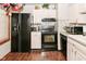 Modern kitchen featuring black appliances, mosaic tile backsplash, and wood-look floors at 114 E 27Th St, Indianapolis, IN 46205