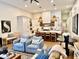 Open concept living room boasts white cabinets, kitchen island and dining area with light hardwood flooring at 114 S Walnut St, Muncie, IN 47305