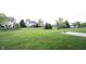 Large backyard featuring lush green grass, mature trees, and surrounding houses at 12493 Loudoun Pl, Fishers, IN 46037