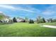 Large backyard featuring lush green grass, mature trees, and surrounding houses at 12493 Loudoun Pl, Fishers, IN 46037