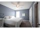 Bedroom featuring blue walls, carpet flooring, a queen-sized bed, and a ceiling fan with integrated lighting at 12493 Loudoun Pl, Fishers, IN 46037