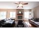 Comfortable living room with hardwood floors, fireplace, ceiling fan, and lots of natural light at 12493 Loudoun Pl, Fishers, IN 46037