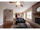 Bright living room has hardwood floors, brick fireplace, and ceiling fan, connecting to the kitchen at 12493 Loudoun Pl, Fishers, IN 46037