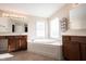 This main bathroom features a large soaking tub, dual vanities and a large window at 12493 Loudoun Pl, Fishers, IN 46037