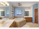 Well-lit bathroom boasts a soaking tub, double vanities, and neutral tiling at 12608 E 86Th St, Indianapolis, IN 46236