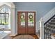 Inviting foyer featuring double doors with glass panels, adjacent to a staircase, and a large window for natural light at 12608 E 86Th St, Indianapolis, IN 46236