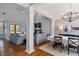 Open-concept living and dining area with hardwood floors, elegant columns, a fireplace, and comfortable gray sofas at 12608 E 86Th St, Indianapolis, IN 46236