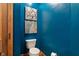 Powder room featuring a toilet, dark blue walls, and decorative wall art at 12608 E 86Th St, Indianapolis, IN 46236