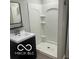 Bright bathroom featuring a white shower with built in shelving and dark vanity at 1301 Stafford Rd, Plainfield, IN 46168