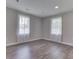 Cozy bedroom with wood floors, neutral paint, and two large windows with natural light at 1301 Stafford Rd, Plainfield, IN 46168
