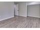 Neutral bedroom with gray walls, gray plank flooring, white trim and doors, and closet with clothes rack at 1301 Stafford Rd, Plainfield, IN 46168