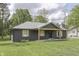 Charming one-story home with dark siding, wood accents, covered porch, and a well-manicured front lawn at 1301 Stafford Rd, Plainfield, IN 46168