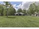 A picturesque one-story home with dark siding and light wood accents on a spacious green lawn at 1301 Stafford Rd, Plainfield, IN 46168