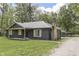 A charming single-story home with a stone chimney and covered porch, surrounded by a green lawn at 1301 Stafford Rd, Plainfield, IN 46168