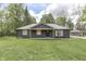 Charming single-story home featuring dark siding, light wood accents, and a well-maintained lawn at 1301 Stafford Rd, Plainfield, IN 46168
