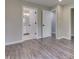 Hallway with open doorways to a bedroom and bathroom, featuring wood-look floors and neutral paint at 1301 Stafford Rd, Plainfield, IN 46168