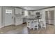 Updated kitchen features white cabinets, stainless appliances, island with seating, and wood flooring at 1301 Stafford Rd, Plainfield, IN 46168