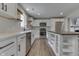 Updated kitchen features white cabinets, stainless appliances, island with seating, and wood flooring at 1301 Stafford Rd, Plainfield, IN 46168