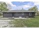 Low angle rear exterior view of gray home with well-maintained yard, siding, and grey roof at 1301 Stafford Rd, Plainfield, IN 46168