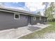 Low angle rear exterior view with gravel, cement pad, siding, and gray roof at 1301 Stafford Rd, Plainfield, IN 46168