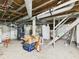 Unfinished basement with utility connections, white refrigerator, and staircase at 1408 W Jackson St, Muncie, IN 47303