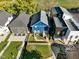 Aerial view of the blue house with dark grey roof and fenced backyard between two other homes at 1417 E Michigan St, Indianapolis, IN 46201
