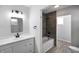 Bathroom with white vanity, neutral walls, and a tiled shower and tub at 1417 E Michigan St, Indianapolis, IN 46201