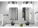 Bright bathroom featuring dual sinks, gray quartz countertops, black fixtures and mirrors reflecting a glass-enclosed shower at 1417 E Michigan St, Indianapolis, IN 46201