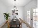 Bright dining room featuring a modern light fixture, contemporary wall art, table with seating, and patio doors at 1417 E Michigan St, Indianapolis, IN 46201