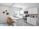 Modern kitchen featuring white cabinets, stainless steel appliances, and a breakfast bar with wicker stools at 1417 E Michigan St, Indianapolis, IN 46201