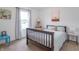 Cozy bedroom featuring a wood bed frame, neutral walls, carpet, and a window with light-filtering curtains at 1417 Layton Rd, Anderson, IN 46011
