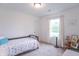 Comfortable bedroom with neutral carpet, white walls, a wooden bed frame, and a window at 1417 Layton Rd, Anderson, IN 46011