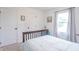 Bright bedroom with neutral walls and carpet, featuring a wood bed frame and a window with gray curtains at 1417 Layton Rd, Anderson, IN 46011