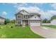 Inviting two-story home with gray siding, white trim, a two-car garage, and a lush front lawn at 1417 Layton Rd, Anderson, IN 46011