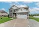 Attractive two-story home showcasing gray siding, a two-car garage, and an expansive driveway at 1417 Layton Rd, Anderson, IN 46011