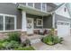 Cozy front porch featuring a sitting area, decorative wreath, and well-maintained landscaping at 1417 Layton Rd, Anderson, IN 46011