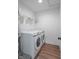 Laundry area features a modern washer and dryer set, wire shelving, and wood-look floors at 1417 Layton Rd, Anderson, IN 46011