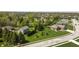 This aerial view shows a brick home with a well-manicured lawn, mature trees, and a two-car garage at 1426 Manchester Dr, Danville, IN 46122