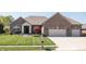 Lovely brick home with a two-car garage and meticulously maintained front yard and garden at 1426 Manchester Dr, Danville, IN 46122