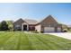 Charming brick home with a manicured lawn, stone accents and a two-car garage at 1426 Manchester Dr, Danville, IN 46122