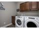 This laundry room features front loading washer and dryer, dark wood cabinets, and stainless steel sink at 1426 Manchester Dr, Danville, IN 46122