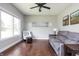 Bright living room with hardwood floors, gray sofa, and large window overlooking the backyard at 1426 Manchester Dr, Danville, IN 46122